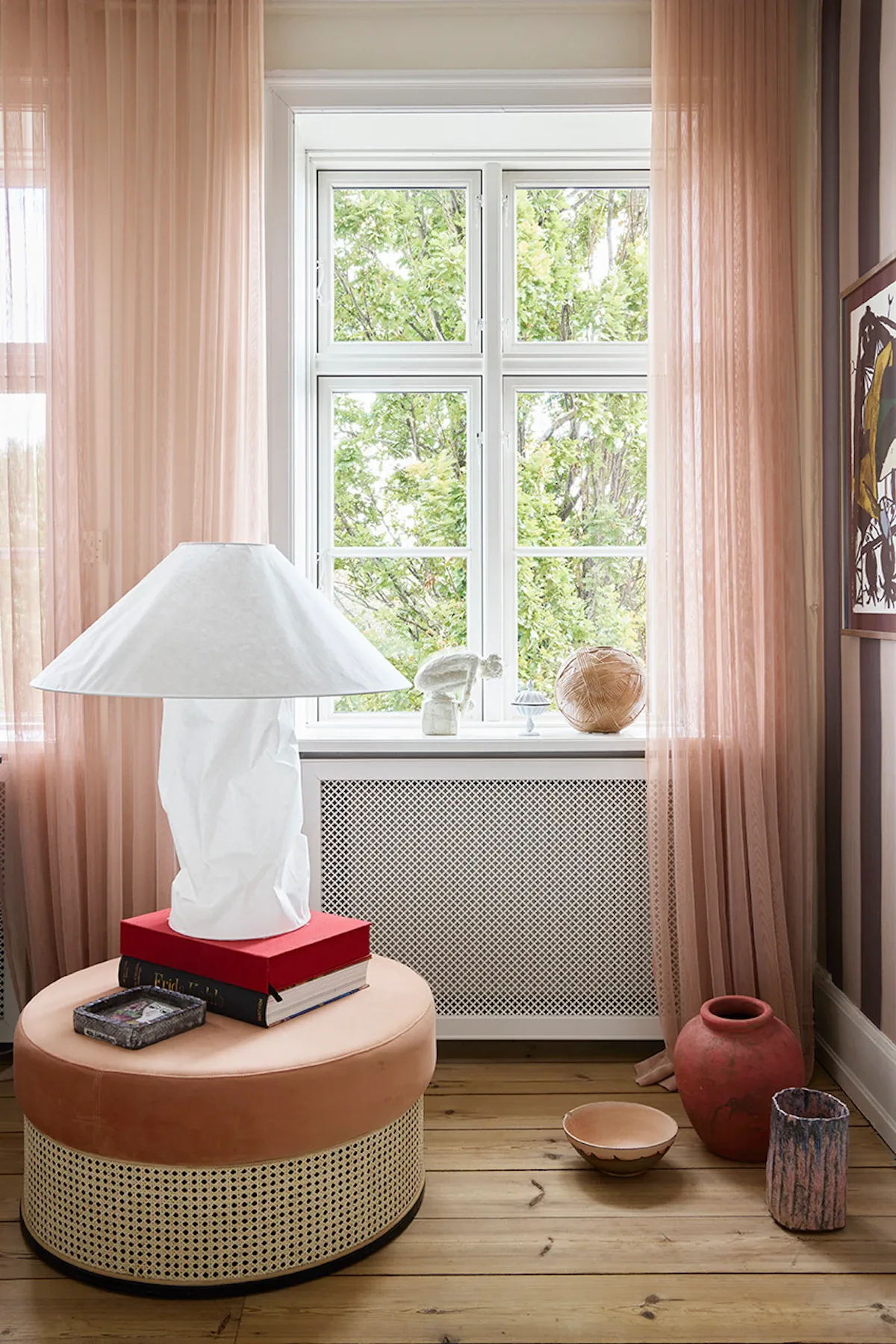 Lyserøde gardiner og puf i flet og velour